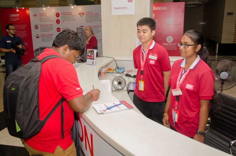 Greeting guests at UNIMY Registration Counter