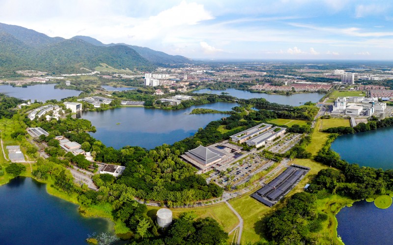 The modern buildings on UTAR campus are integrated with the undulating green hills, blue sky and lake scenery.