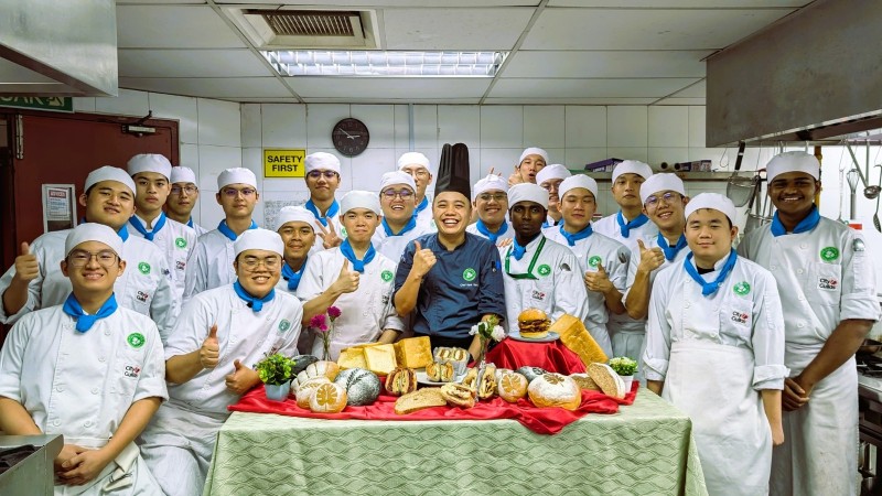 Students and our chef work together in harmony, kneading dough and shaping buns. The kitchen is filled with the warm scent of freshly baked bread, creating a delightful atmosphere of learning and creation