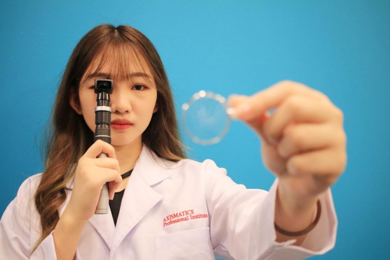 英国配镜与验光师课程的学生正在使用检眼镜（Retinoscope）进行屈光临床测试（Refraction Clinical class practice）。