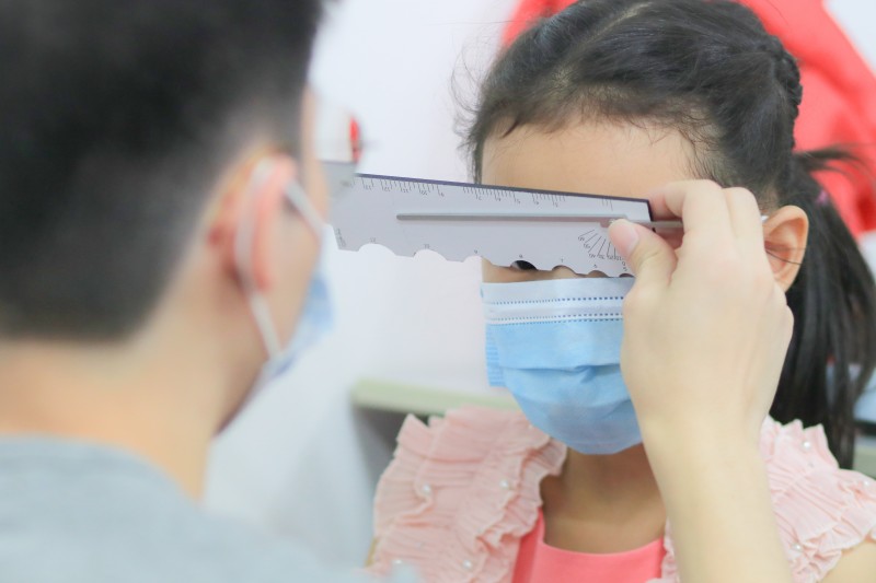 英国配镜与验光师课程的学生在实践课中学习测量孩童的面部，以定制出合适他们的眼镜。