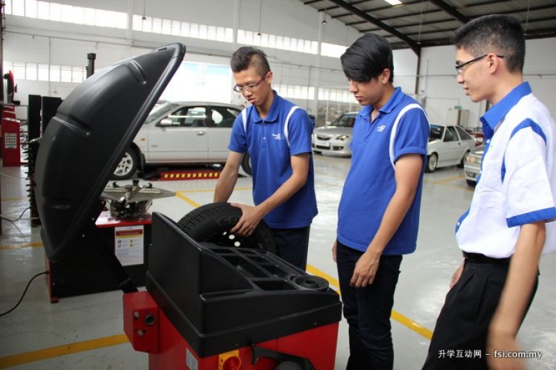 学生在导师监督下，学习如何操作车胎平衡 (Wheel Balance) 机器。